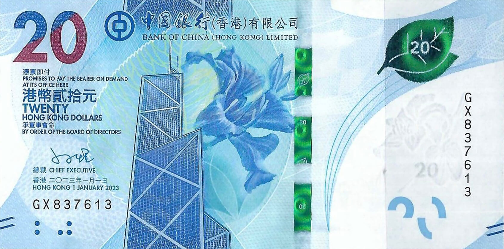 The photo depicts the Hong Kong (BOC) 20-dollar note, series B921c, with the new issue date of January 1, 2023. It features modern design elements and security features, with distinctive cultural motifs representative of Hong Kong.