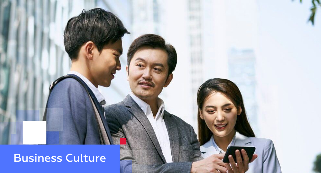 Three Chinese professionals chatting outside an office tower — illustrating business culture in China