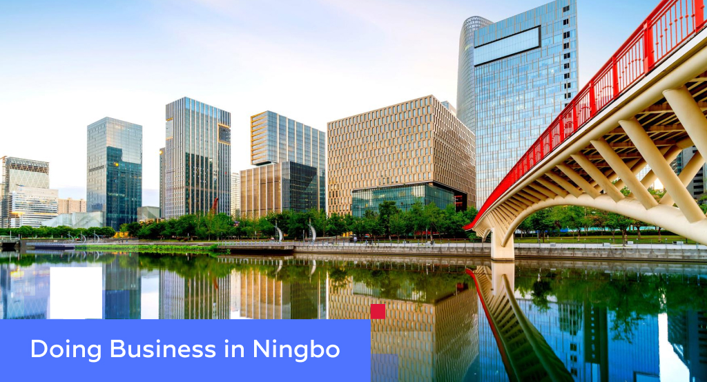Modern Ningbo skyline with a red arched bridge over a calm river — illustrating doing business in Ningbo, China