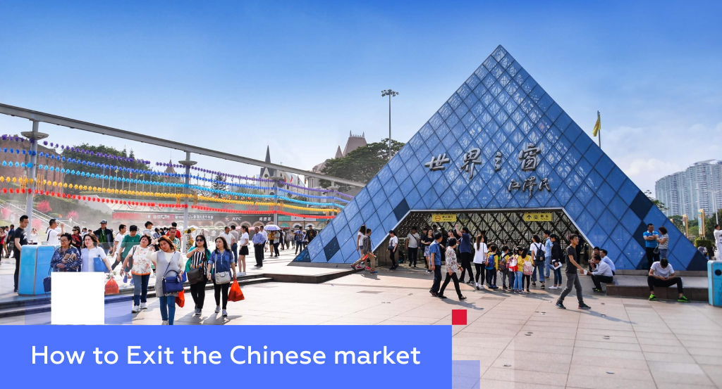 Crowd by the glass-pyramid entrance of Shenzhen’s Window of the World theme park — illustrating how to exit the Chinese market