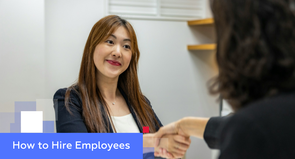 Smiling Asian woman in a black blazer interviewing across a desk — illustrating how to hire employees in China