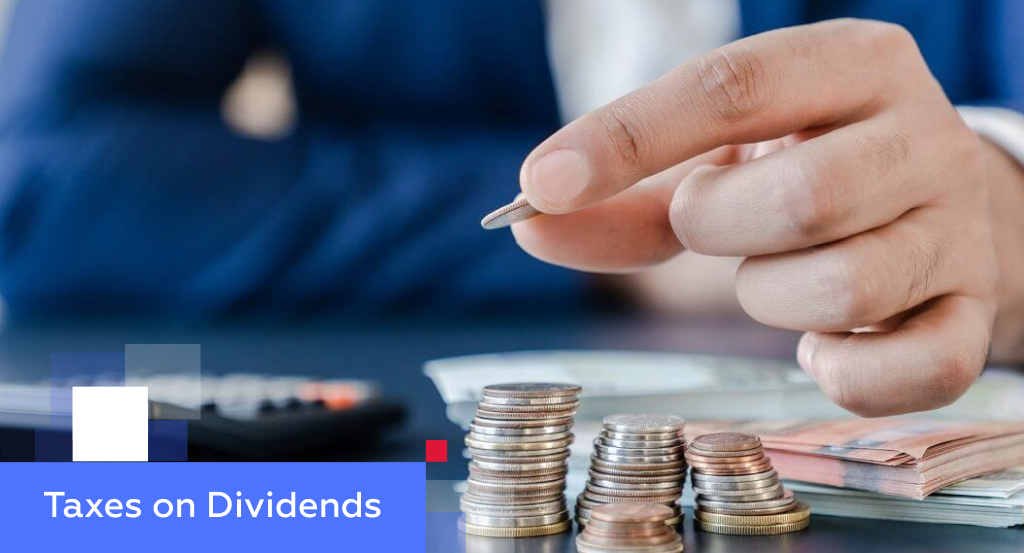 Hand stacking coins beside banknotes and a calculator — illustrating taxes on dividends in China